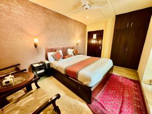 拉合尔Shelton Hotel Lahore的一间卧室配有一张床,浴室设有水槽
