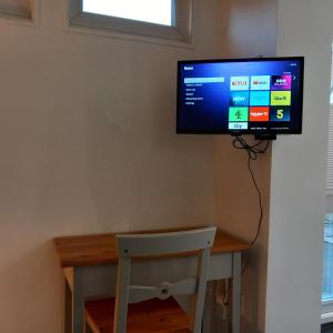 Thistles -Private Entrance Studio的书桌上方的墙上设有平面电视