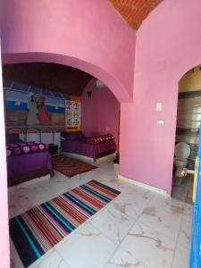 阿斯旺Kamel House的客厅设有粉红色的墙壁和紫色的家具