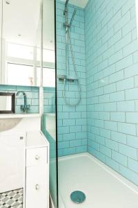 伦敦Central 1 BR Apartment *Zone 1* Elephant and Castle的浴室设有蓝色瓷砖淋浴。