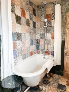 FrithamBelle Vue Farm B&B的带浴缸的浴室和瓷砖墙