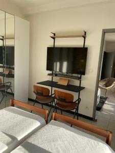 马赛Appart 60 m2 séjour sur terrasse sud et 2 chambres gare Saint-Charles的一间卧室配有一张床和一张带椅子的桌子
