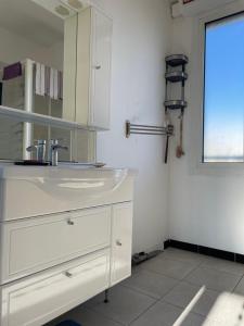 马赛Appart 60 m2 avec terrasse 35m2 séjour sud et 2 vraies chambres gare Saint-Charles的白色的浴室设有水槽和窗户。