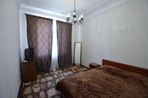 尼古拉耶夫Apartments on Sobornaya Street near the waterfront的一间卧室配有床和带窗帘的窗户