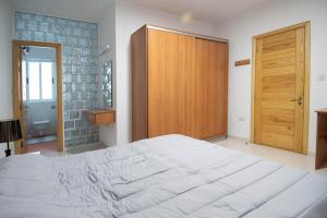 斯利马Venus Apartment的卧室配有一张白色大床和木门