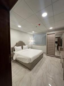 达曼الساعه 60 الفندقيه的一间卧室配有一张大床和镜子
