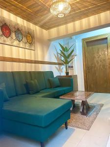 阿布贾RUDISH COTTAGE (COZY & PRIVATE)的客厅配有蓝色的沙发和桌子