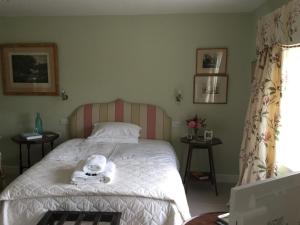 谢伯恩Clare Cottage的一间卧室配有带毛巾的床