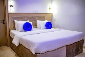 EffurunWELLINGTON HOTEL LIMITED的一张大床,上面有两个蓝色的枕头