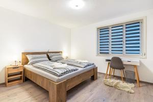 阿尔皮尔斯巴赫Ferienhaus Burghalde mit Sauna的一间卧室配有一张床、一张书桌和一个窗户。