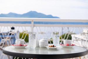 卢特拉艾季普苏Zoe Seaside的阳台上的桌子上放着玻璃杯和碗的食物
