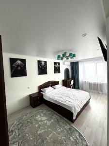 奎兹洛达Уютная, светлая квартира-студия в районе Акмешит的卧室配有一张床,墙上挂有绘画作品