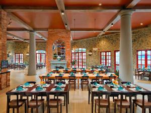 岘港岘港法国村巴纳山美居酒店的大型用餐室配有桌椅