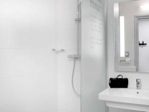 克莱蒙费朗Hôtel ibis Styles Clermont-Ferrand Gare的带淋浴和盥洗盆的白色浴室