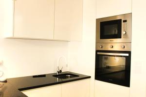 布拉加G 0.9 - G.oogle Nest Smart House的厨房配有水槽和微波炉