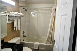 坎卢普斯Rodeway Inn & Suites的带淋浴、卫生间和盥洗盆的浴室