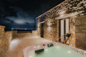圣安娜纳克索斯Naxos Privilege Villas的一间带浴缸的浴室,位于大楼的一侧
