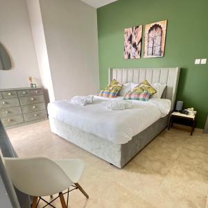迪拜Jumeirah lake towers的一间卧室设有一张大床和绿色的墙壁