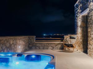 圣安娜纳克索斯Naxos Privilege Villas的晚间在阳台上提供热水浴池和椅子
