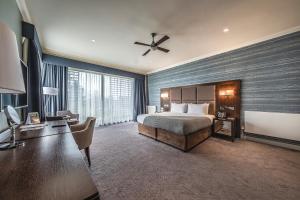 科尔切斯特威文霍府酒店 的酒店客房带一张床铺、一张书桌和一间卧室