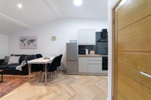 利物浦Orange Rentals- Loft Studio, City Centre Liverpool, Sleeps 4 guests的一间带桌子的客厅和一间厨房