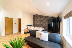 利物浦Orange Rentals- Loft Studio, City Centre Liverpool, Sleeps 4 guests的客厅配有沙发和1张床
