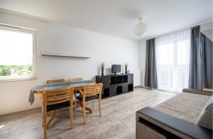 华沙Krzyżówki Comfort Apartment的客厅配有桌椅和1张床