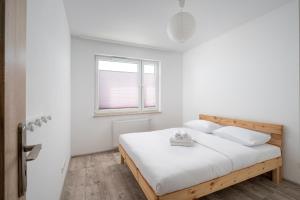 华沙Krzyżówki Comfort Apartment的白色的卧室设有床和窗户