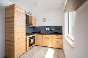 华沙Krzyżówki Comfort Apartment的一个带木制橱柜和大窗户的厨房