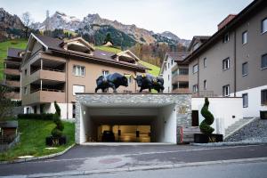 梅赫陶尔Melchtal Resort Apart Hotel的建筑顶部有两只公牛的车库