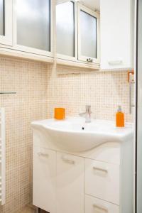 罗马Locazione Turistica- Maxxi loft的一间带白色水槽的浴室和两个窗户