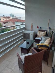 布德瓦Jana apartment Budva的阳台配有桌椅和沙发。