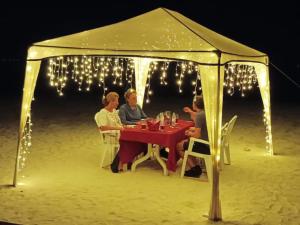 妮兰朵南环礁Rindali Maldives Maaenboodhoo的一群人坐在海滩帐篷里的桌子上