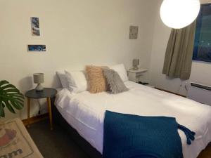 BrightonOcean Retreat的卧室配有白色的床和桌子