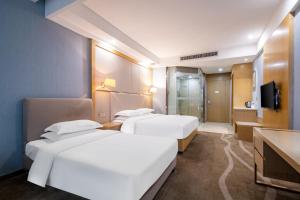 厦门厦门舒悦酒店的酒店客房设有两张床和电视。