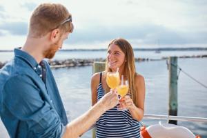 艾恩松Hausboot WELL - Husbåd WELL的一位男人和女人拿着香槟杯