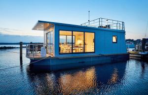 艾恩松Hausboot WELL - Husbåd WELL的水面上的蓝色房子