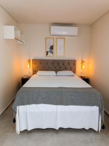 马拉戈日Flats Marina Maragogi的一间卧室配有一张大床,两边都配有两盏灯