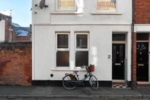 牛津Boujee & chic city centre house的停在白色房子前面的自行车