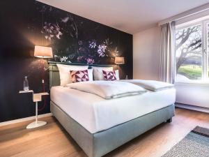 汉堡翰堡特瑞德尔伯格施泰根博阁酒店的卧室配有白色大床和鲜花墙
