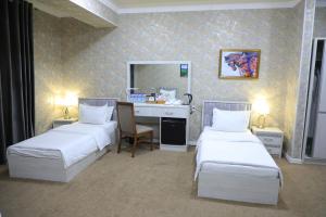 纳沃伊HOBIZ Hotel的酒店客房配有两张床和一张书桌