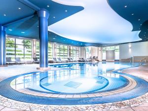 汉堡翰堡特瑞德尔伯格施泰根博阁酒店的大型游泳池,位于酒店,拥有大型天花板