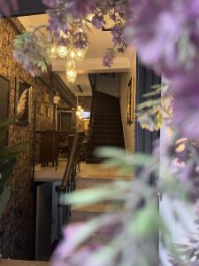 伊斯坦布尔Perazre Hotel的餐厅内带楼梯和紫色鲜花的走廊