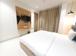 瓜廖尔HOTEL SCARLET的卧室配有白色的床和平面电视。