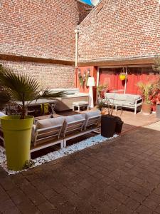 里尔Studio indépendant et calme avec Jacuzzi à Lille的砖砌建筑中一个配有沙发和植物的庭院