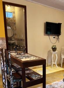 安格拉杜斯雷斯Chalé Maria Bonita - Ilha Grande, RJ的一间设有桌子和墙上电视的用餐室