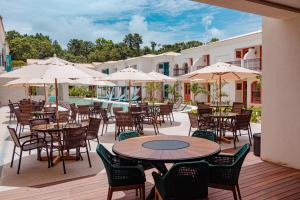伊塔卡雷Resende Imperial Hotel & Spa的一个带桌椅和遮阳伞的户外庭院。