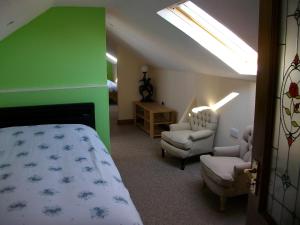 ClonmacnoiseClonmacnoise B&B的一间卧室设有床和椅子,还有一堵绿色的墙