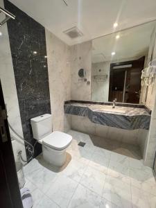 麦加فندق إي دبليو جي العزيزية的浴室配有卫生间、盥洗盆和浴缸。