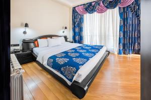 第比利斯Cron Palace kosher Tbilisi Hotel的一间卧室配有一张带蓝白色床单的大床